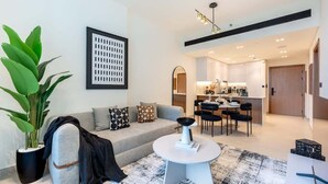 Ein modernes Wohnzimmer mit einer Couch, einem Couchtisch und einer großen Topfpflanze.