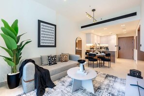 A modern living room with a sofa, coffee table, and a large potted plant.