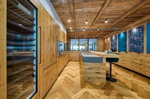 Una cocina moderna con armarios de madera, una isla central y un suelo con estampado de espiga.
