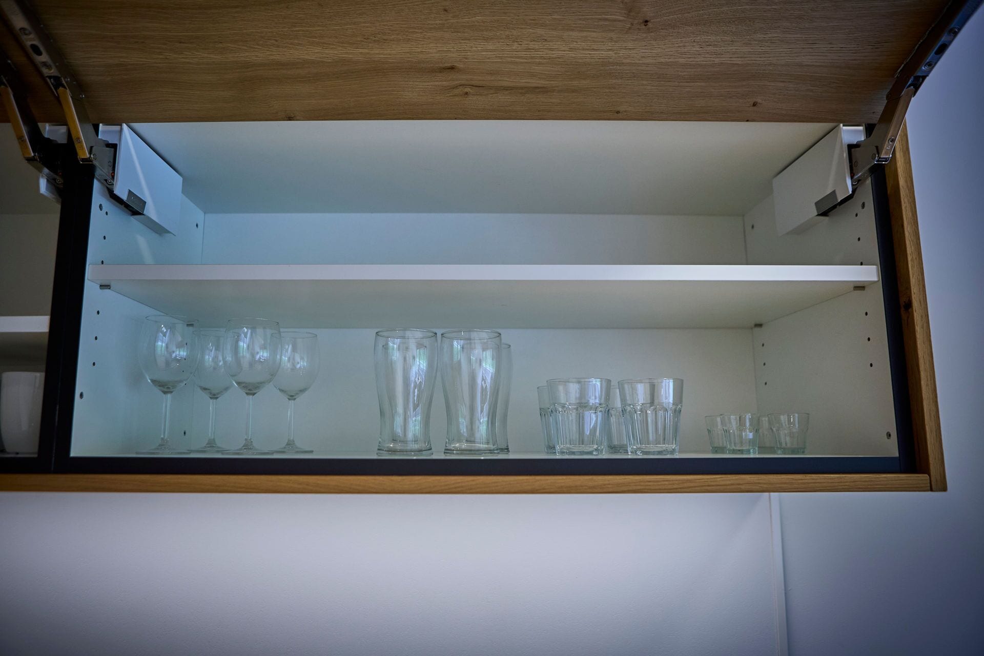 A storage cabinet with multiple shelves, containing various glassware items.