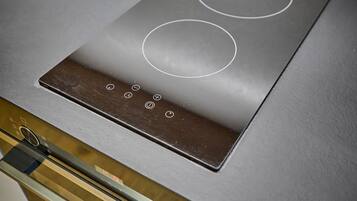 A modern kitchen with a built-in induction cooktop and a stainless steel oven.