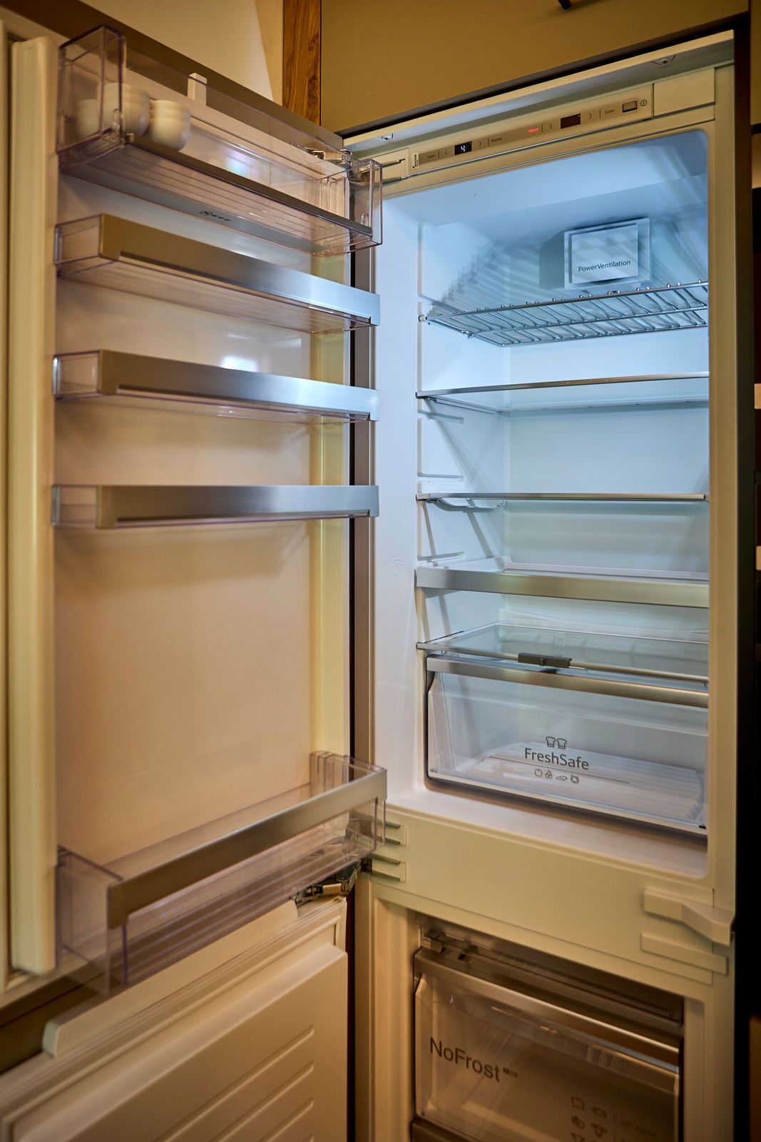 An open refrigerator with multiple shelves and a freezer compartment.