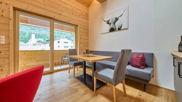 A cozy room with wooden walls and floors, a sofa, a table, and a chair.