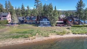 A lakeside residential area with houses, a dock, and a clear view of the water.