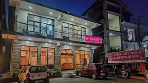 A hotel with a modern design, featuring a two-story structure, a balcony, and a signboard advertising the hotel. - Hotel City Gold - Hotel in Dharamshala (Dharamshala)