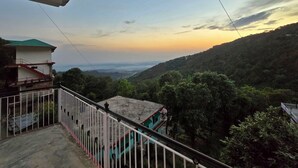 A balcony with a view of a hilly landscape during sunset. - Hotel City Gold - Hotel in Dharamshala (Dharamshala)