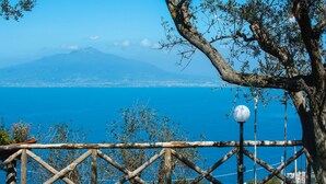 Une clôture en bois avec une balançoire, un lampadaire et une vue sur une montagne et un lac.