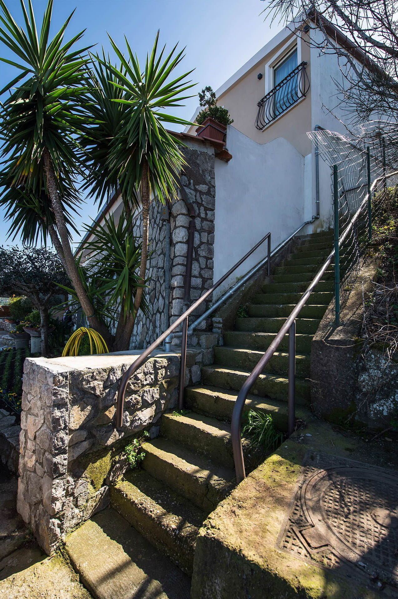 A stone staircase leading to a building with a balcony.