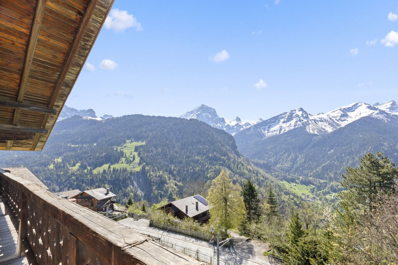 A mountain view with a wooden structure and a small building with a sloped roof.