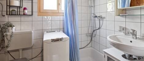 A bathroom with a shower, toilet, and sink.
