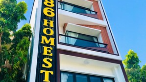Un edificio moderno con un letrero llamativo que dice "COZY 86 HOMESTAY".