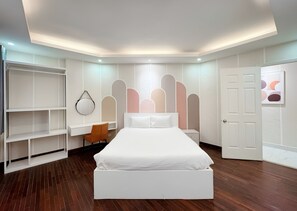 Ein modernes Schlafzimmer mit einem großen Bett, einem Schreibtisch und integrierten Regalen.