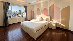 Une chambre d’hôtel moderne avec un grand lit, une table de chevet et une vue sur le paysage urbain.