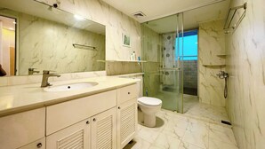 Une salle de bain moderne avec un lavabo en marbre, des toilettes et une douche à parois de verre.