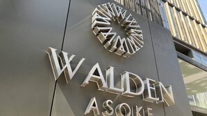 Un edificio dal design moderno, con un logo ben visibile e il nome "WALDEN ASOIKE" in grandi lettere metalliche.