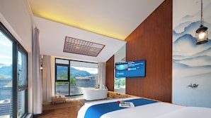 A modern hotel room with a large bed, a bathtub, and a TV on the wall. - Riverside Peak Lodge Zhangjiajie Wulingyuan National Park (Zhangjiajie)