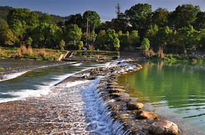 Ein Fluss mit steinigem Grund und einem kleinen Wasserfall.