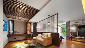 A modern living room with a sofa, coffee table, and a decorative partition. - Riverside Peak Lodge Zhangjiajie Wulingyuan National Park (Zhangjiajie)