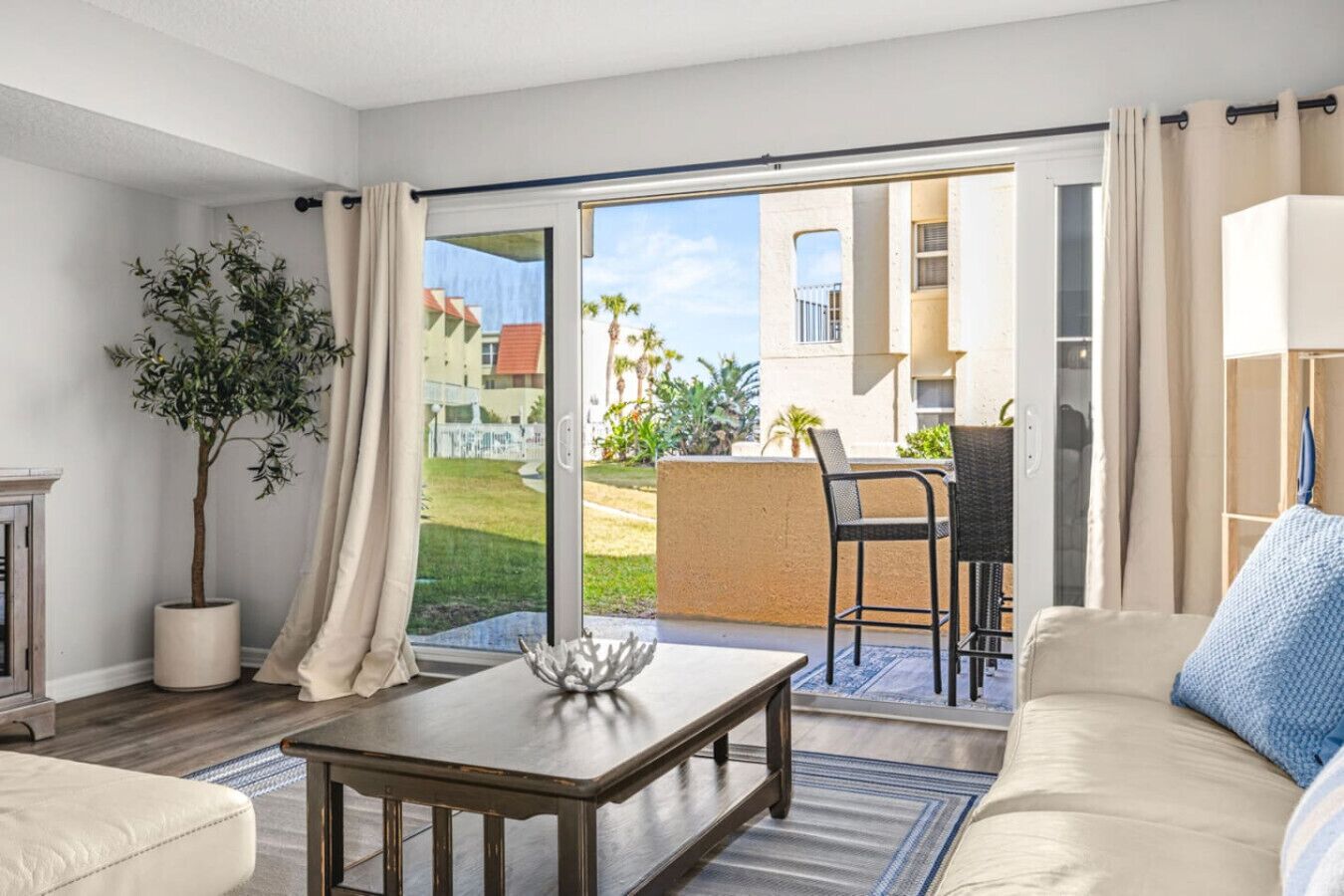 Soak in stunning views from the living room, where floor-to-ceiling sliders open effortlessly to the patio—blurring the line between indoor comfort and coastal outdoor living.
