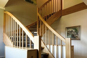 Staircase leads to an upper level with a painting above.
