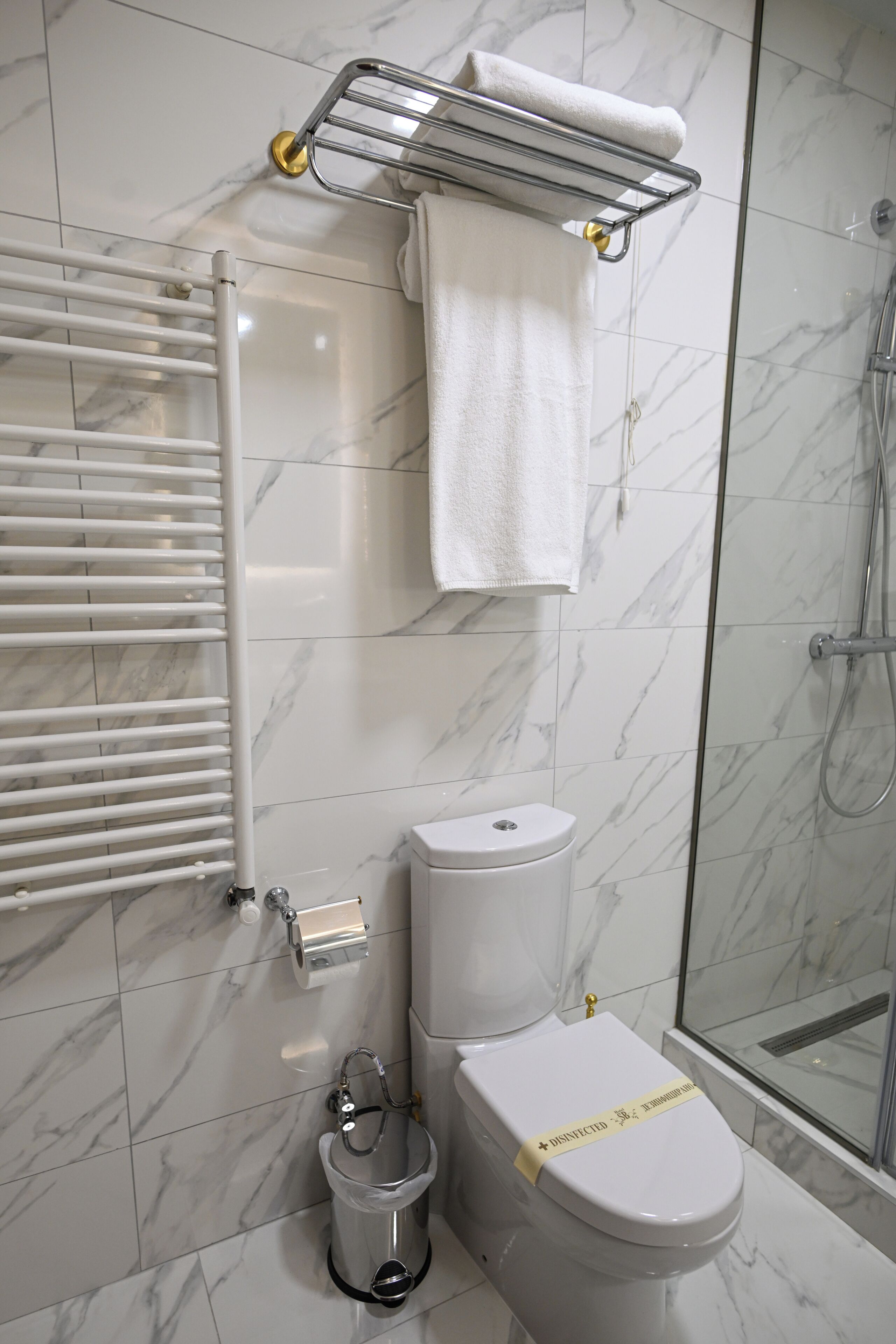 Un baño moderno con inodoro, bidé y cabina de ducha de vidrio.