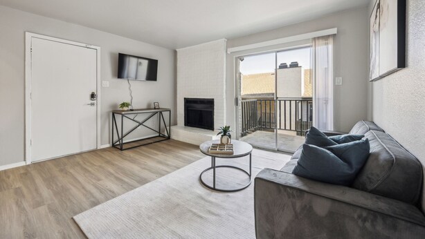 Una sala de estar moderna con chimenea, un sofá, una mesa de centro y un televisor montado en la pared.