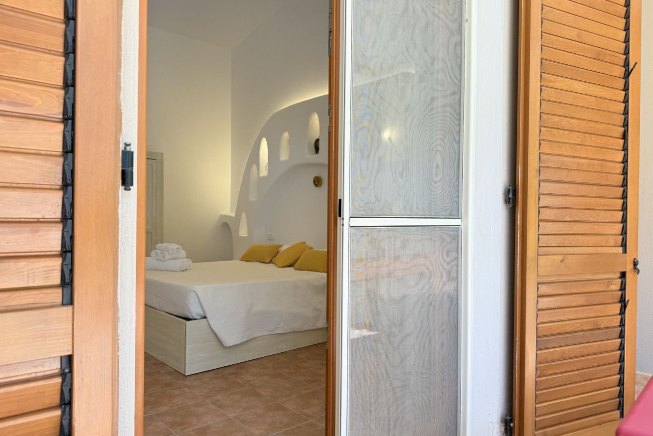 Un dormitorio con cama, almohadas y mesita de noche.