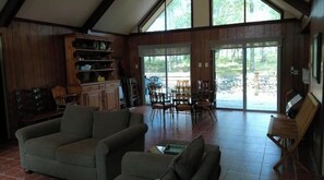 Relax in this spacious living area with a high ceiling and large windows offering a view of the outdoors.