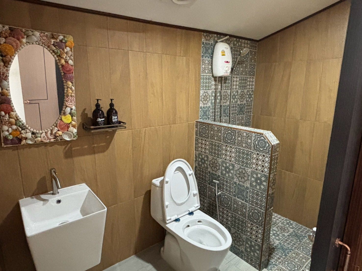 A bathroom with a toilet, sink, and shower.