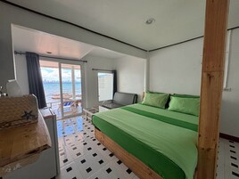 Habitación de hotel con cama, escritorio, silla y vista al mar.