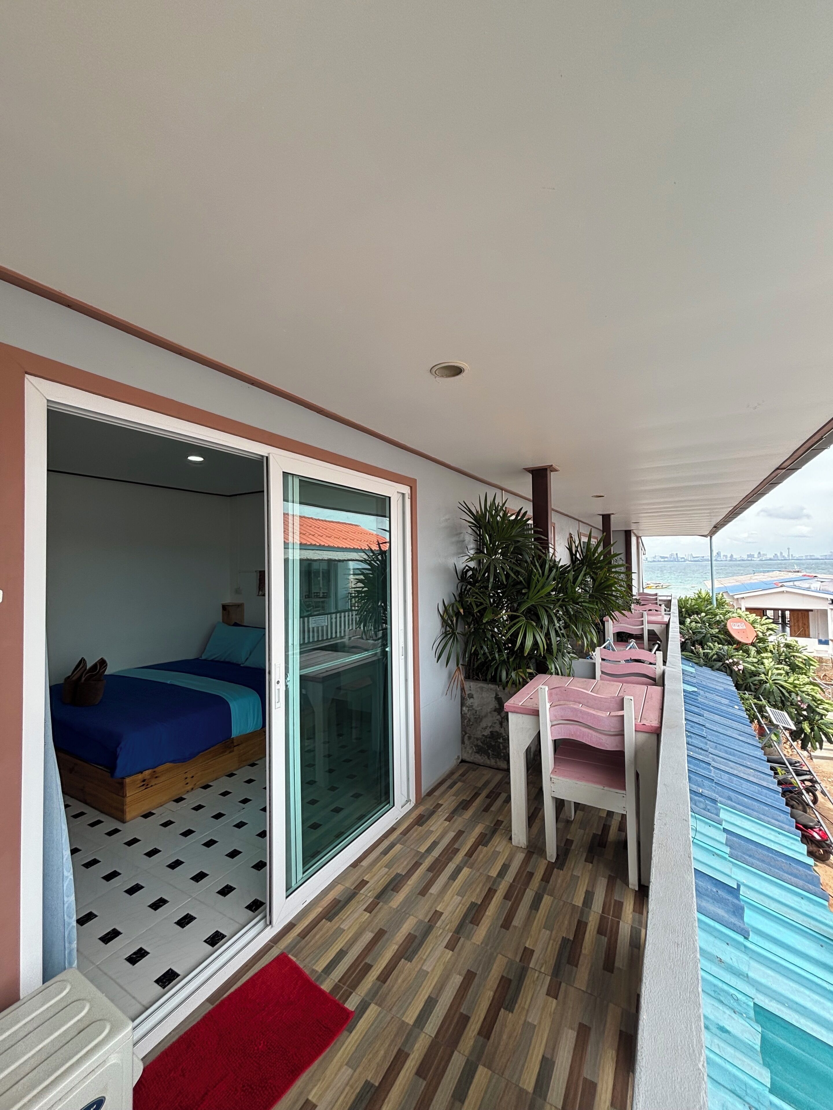 A balcony with a bed, a table, and chairs.