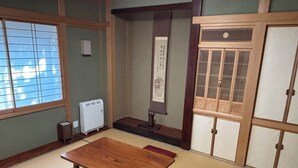 A traditional Japanese room with tatami flooring, a low wooden table, and sliding doors.