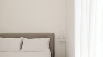 A neatly made bed with white bedding and a grey headboard.