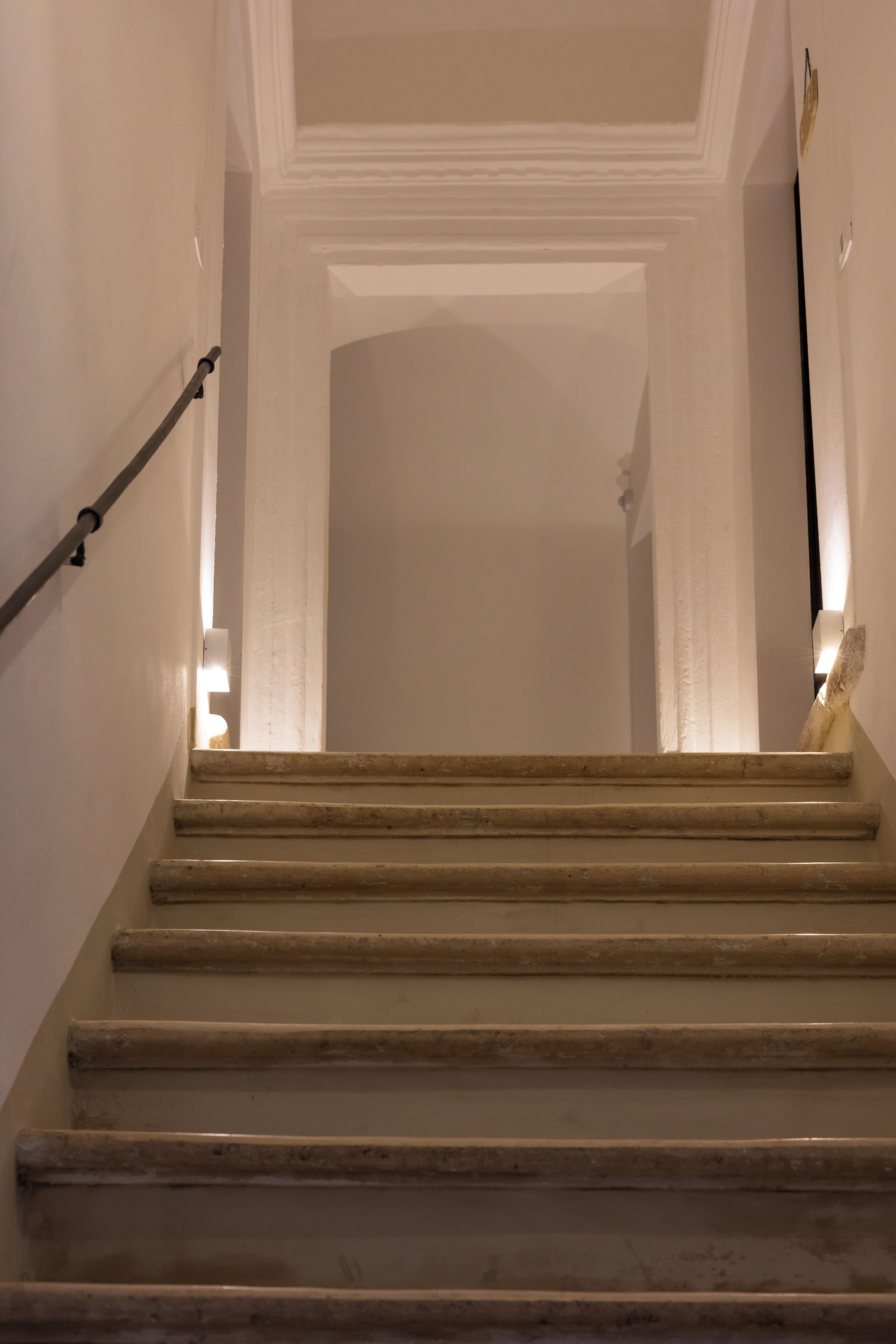 En trappa med ett ledstång, som leder upp till en liten plattform med en lampa.