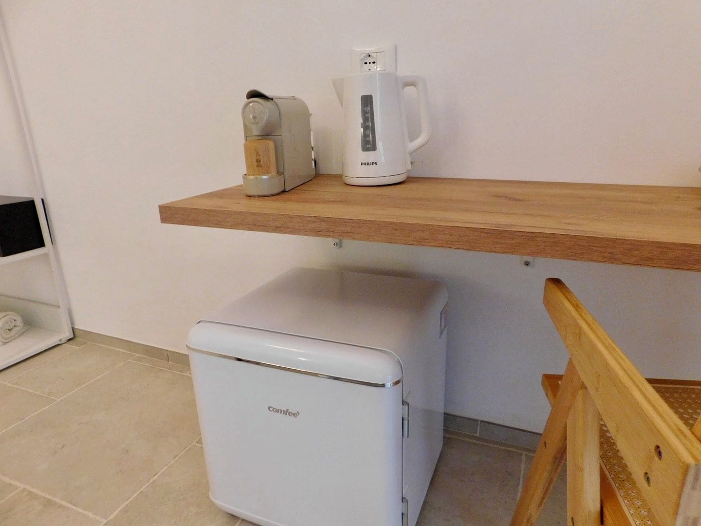 A kitchenette with a coffee maker, a toaster, and a compact refrigerator.