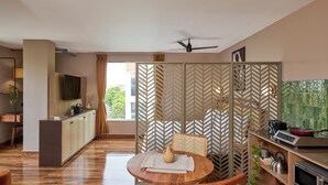 Eine moderne Küche mit Essbereich, einem Fernseher und einem Deckenventilator.