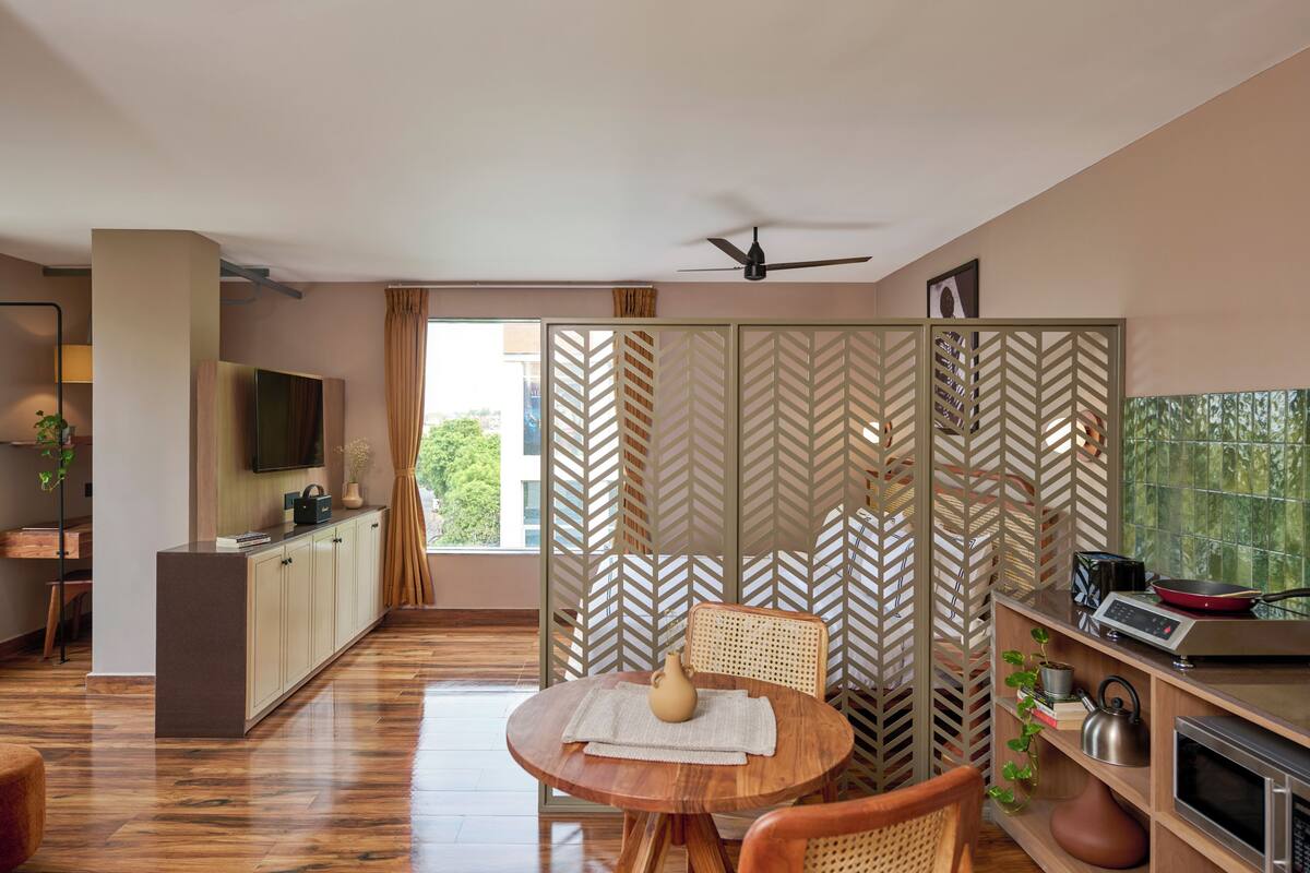 A modern kitchen with a dining area, a television, and a ceiling fan.