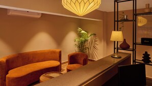 A modern interior with a sofa, a table, a lamp, a plant, and a geometric pendant light. - Minimalist - The Varanasi Edit (Varanasi)