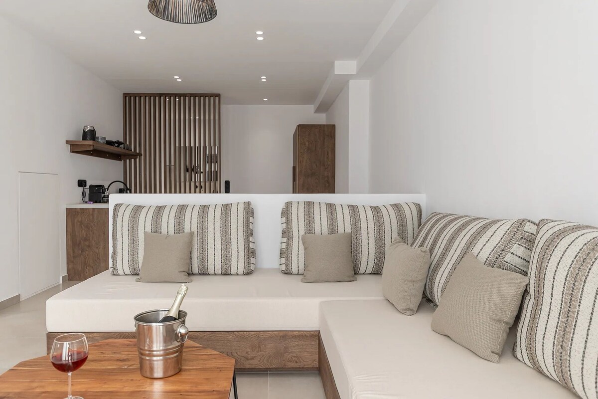 A modern living room with a sofa set, a coffee table, and a wine glass.