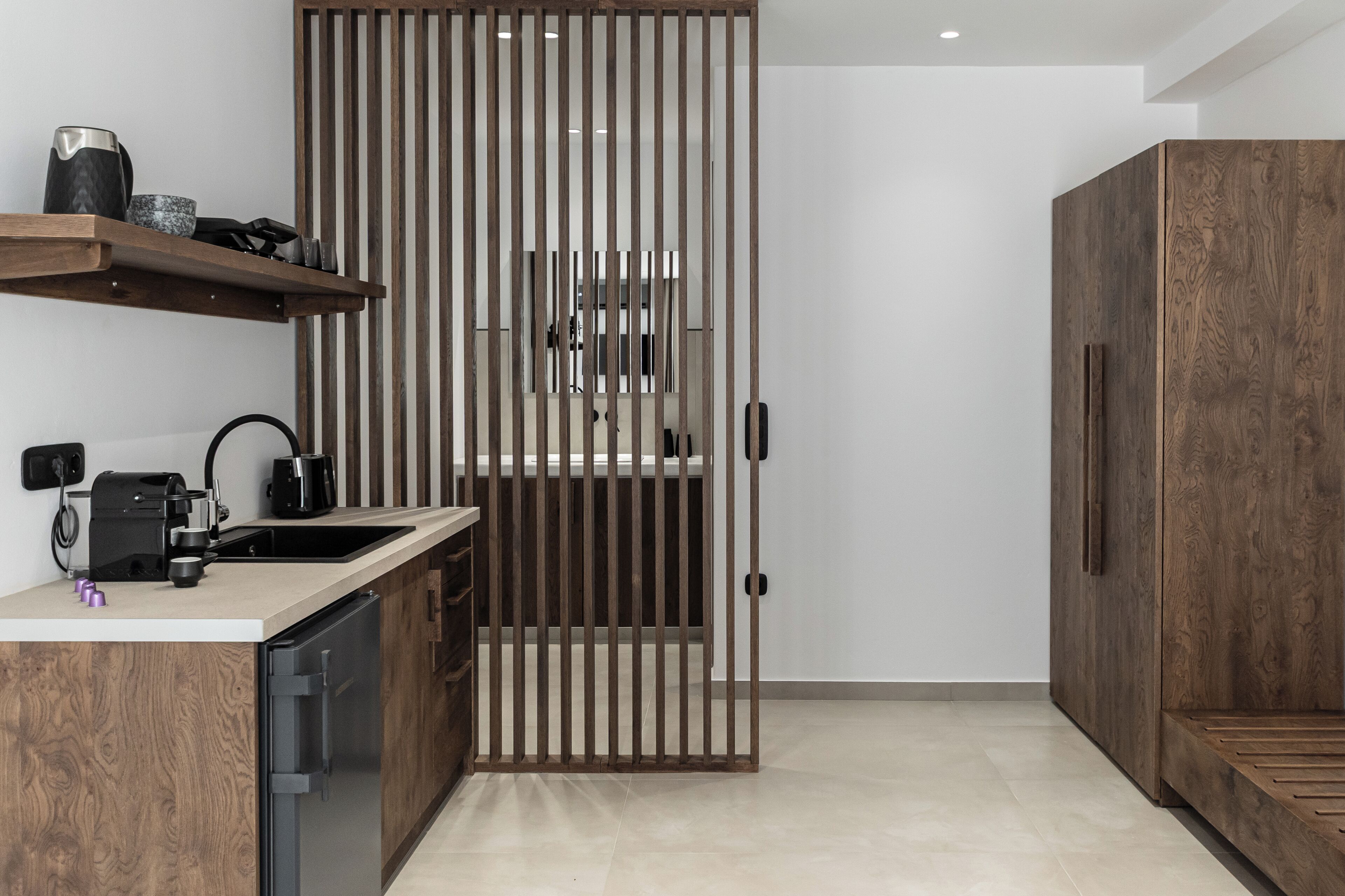 Une cuisine moderne avec des meubles en bois, une machine à café et un lave-vaisselle encastré.
