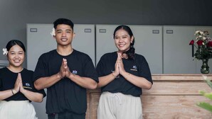 Three individuals in black t-shirts with a logo, standing in a room with lockers in the background. - Kemala Living Sanur (Denpasar)