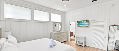 Un dormitorio con una cama grande, un aparador, un espejo y un cuadro en la pared.