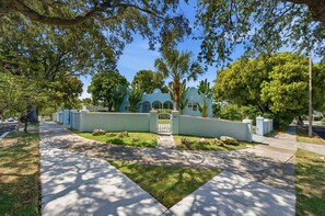 A residential property with a paved driveway, a gated entrance, and a well-maintained lawn.