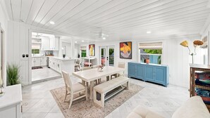 A spacious kitchen with white cabinetry, a dining area with a large table and chairs, and a blue cabinet. - Welcome to Your West Palm Beach Getaway! (West Palm Beach)