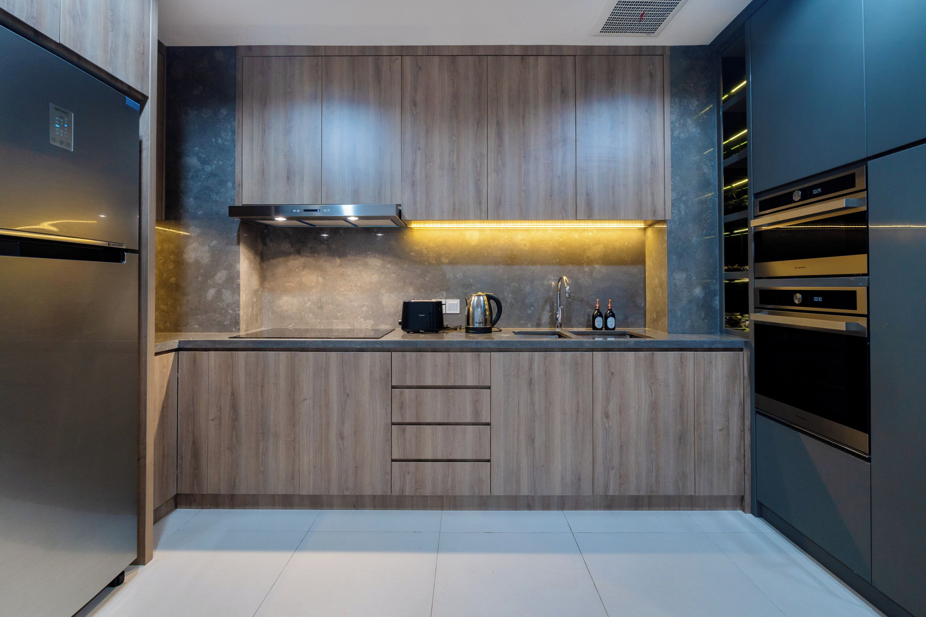 A modern kitchen with wood paneling, stainless steel appliances, and a built-in oven.