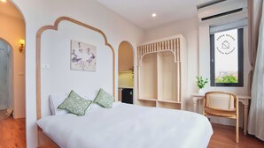 Ein Hotelzimmer mit Bett, Sessel, Schreibtisch und einem Fenster mit Blick.