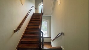 Una escalera de madera con barandillas a cada lado, que lleva a un piso superior.