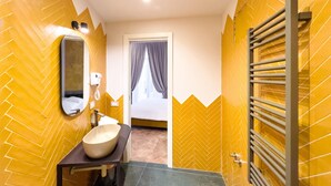 A bathroom with a herringbone-patterned wall, a round sink, a mirror, and a towel rack. - Guest House Le Sei Porte   Porta Elina (Salerno)