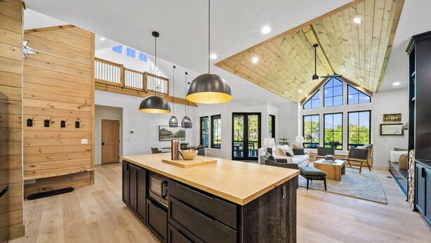 A spacious kitchen with a large island, wooden accents, and pendant lighting. - Lost Bark Lodge at Eagles Nest Great Camp, hot tub, pool table, fenced yard (Banner Elk)