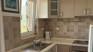 A kitchen with a sink, stove, and window.